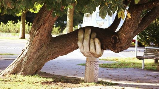sculpture of hand holding tree